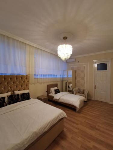 a bedroom with two beds and a chandelier at Holiday inn Adnan boutique hotel and pool in Gabala