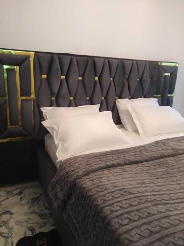 a bedroom with a large bed with white pillows at chambre meublé Douala bonapriso Cameroun, eau chaude, clim, gardien, wifi haut débit in Douala