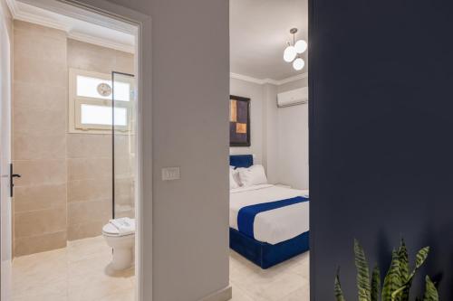 a bathroom with a bed and a toilet in a room at Travelholic Residence Near Mivida in Cairo