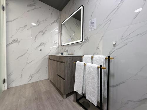 a bathroom with marble walls and a sink and towels at Flôr do Távora in Vila da Ponte
