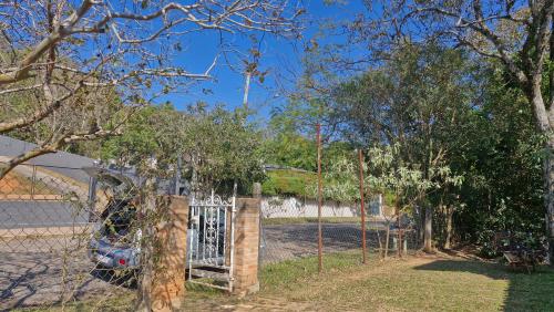 a fence with a gate in a yard with trees at Pe na Pedra quarto 2 in Atibaia