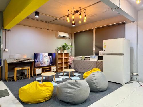 a room with chairs and a refrigerator and a table at Sukhum Huai Khwang Guest House in Bangkok