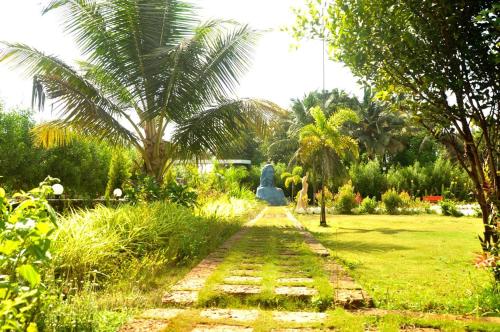 a garden with a statue in the middle of a field at Horizon Grande Apartments - Tarkarli in Malvan