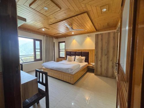 a bedroom with a bed and a wooden ceiling at Mainak Guest House in Dalhousie