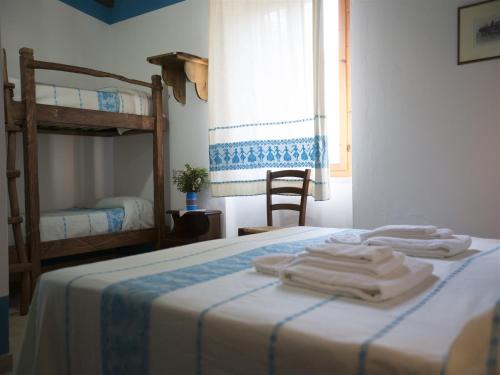 a bedroom with a bed with two bunk beds at Country House S'Ozzastru in Dorgali
