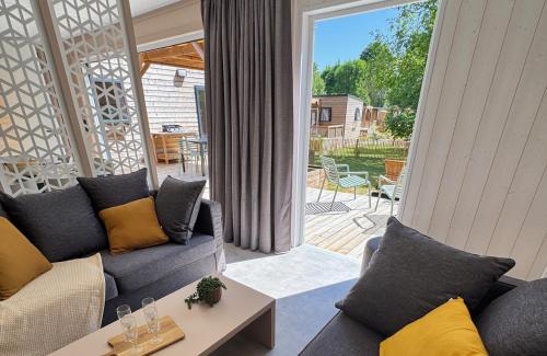 a living room with a couch and a table at Village Collection Le Vauvert in Ormoy-la-Rivière