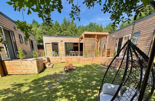 a backyard with a wooden house with a fence at Village Collection Le Vauvert in Ormoy-la-Rivière