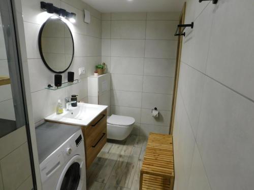 a bathroom with a sink and a washing machine at Baza wypadowa 3 in Leśna