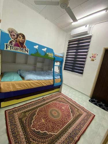 a bedroom with a bunk bed with a rug on the floor at Aisy Homestay 2 in Pengkalan Cepa