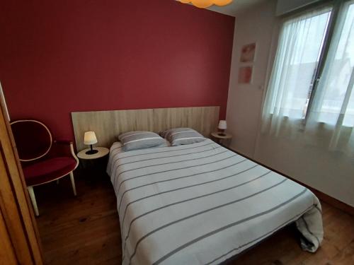 a bedroom with a large bed in a red room at gite notre désir 100 m de la mer in Jullouville-les-Pins