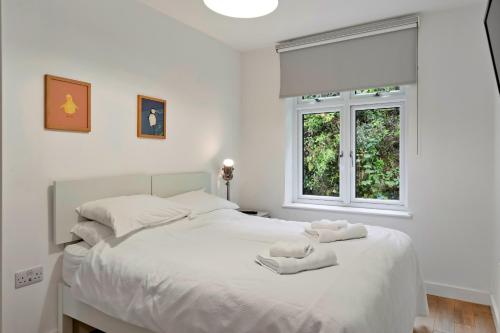 una camera da letto con un letto bianco con due peluche sopra di Finest Retreats - Three Quarter Cottage a Fowey