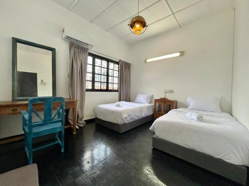 una camera con due letti, uno specchio e una sedia di Cozy 2BR Family Homestay in Shared Bungalow SS2 Petaling Jaya a Petaling Jaya