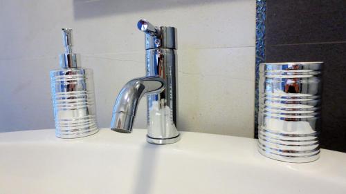 un fregadero con dos grifos y dos tazas. en Masseria Corte Masseriola, en Alberobello