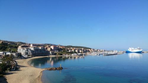 Blick auf einen Strand mit einem Boot im Wasser in der Unterkunft côté plage in Propriano
