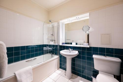 a bathroom with a tub and a sink and a toilet at The Open Arms Hotel in Dirleton
