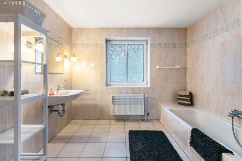 a bathroom with a tub and a sink at Ferienhaus Sprante in Brunsbüttel