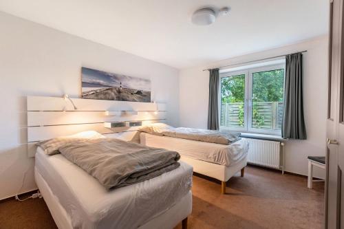 a bedroom with two beds and a window at Ferienhaus Sprante in Brunsbüttel