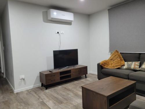 a living room with a couch and a flat screen tv at Welcome to your cozy retreat! two-bedroom home in Flagstaff in Hamilton