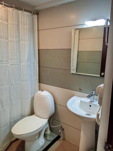 a bathroom with a toilet and a sink at Hotel Armani in Mundakāyam