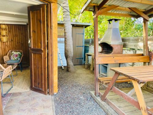 a patio with an outdoor oven and a table at Maisons Familiales 101 m2 et 51 m2 Lagon, Plage & Détente, La Saline-les-Bains in La Saline les Bains