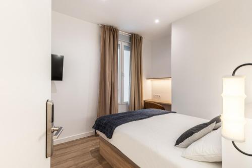 a bedroom with a bed and a window at Queens Bernabéu in Madrid