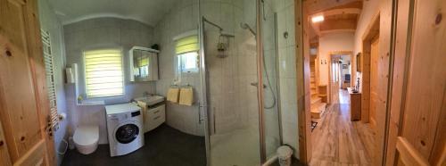 a bathroom with a shower and a washing machine at Ferienhaus Gertrud in Sankt Stefan ob Stainz
