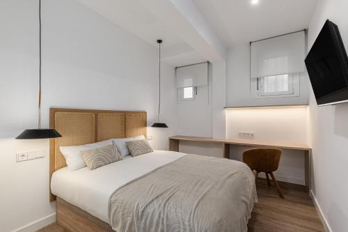a bedroom with a bed and a desk and a television at Queens Bernabéu in Madrid