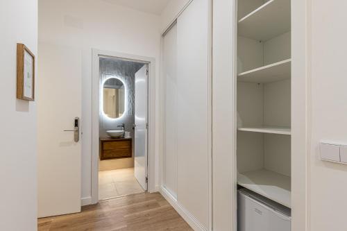 a white bathroom with a sink and a mirror at Queens Bernabéu in Madrid