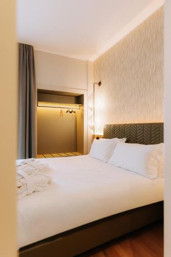 a bedroom with a large white bed with white pillows at Mövenpick Hotel Bari in Bari