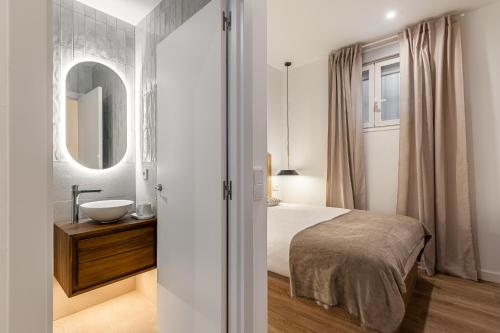 a bedroom with a bed and a sink and a mirror at Queens Bernabéu in Madrid