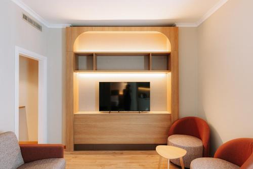 a waiting room with two chairs and a tv at Mövenpick Hotel Bari in Bari