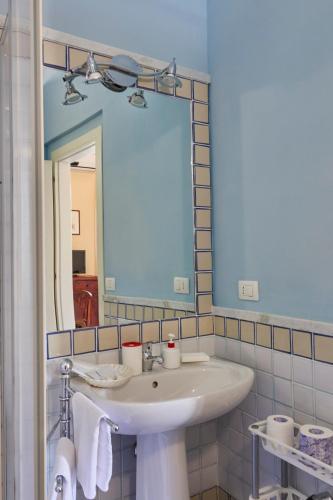 a bathroom with a white sink and a mirror at Alloggio della Posta Vecchia in Agrigento