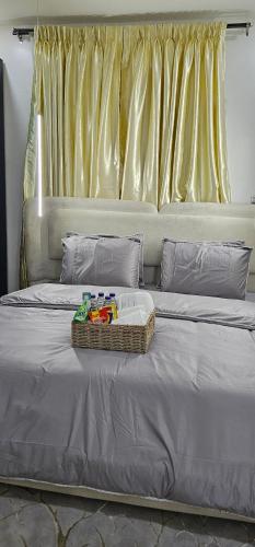 a bed with a basket of toys on top of it at Winters Apartments in Abuja