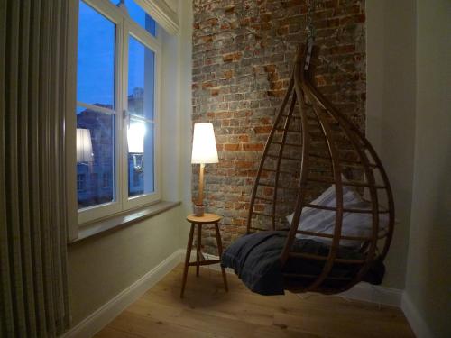 a swing in a room with a lamp and a window at The Doghouse B&B in Bruges