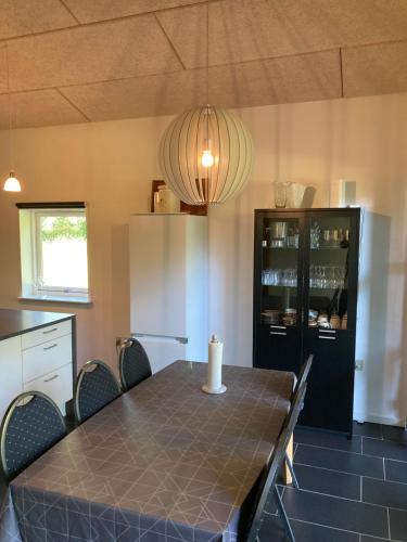 a dining room with a table and chairs and a light at Lerbæk Naturpark in Frederikshavn