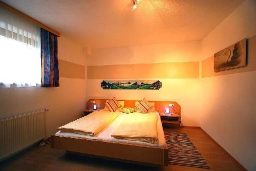 1 dormitorio con 1 cama grande en una habitación con ventana en Panoramablick Ferienwohnung Schiestl, en Brandberg