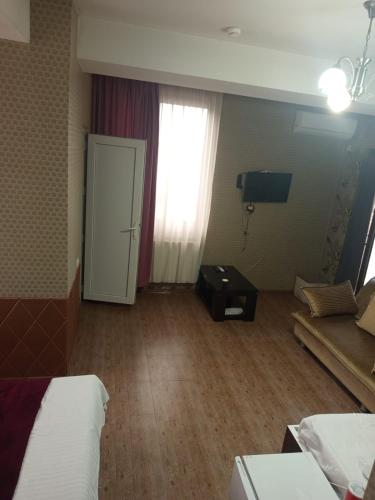 a room with a bed and a couch and a window at Kavela555 in Tbilisi City