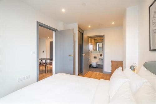 a bedroom with a white bed and a living room at Luxury Apartments in a vibrant part of North London in London