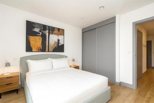 a bedroom with a white bed and a large window at Luxury Apartments in a vibrant part of North London in London
