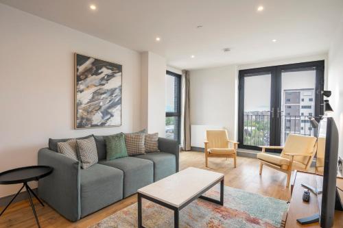 a living room with a couch and a table at Luxury Apartments in a vibrant part of North London in London