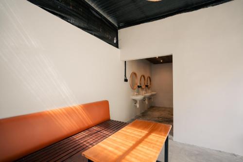 Un banco naranja en una habitación con lavabo. en Kuta Sekeca CoWorking Apartment Close to Kuta Beach, en Jimbaran