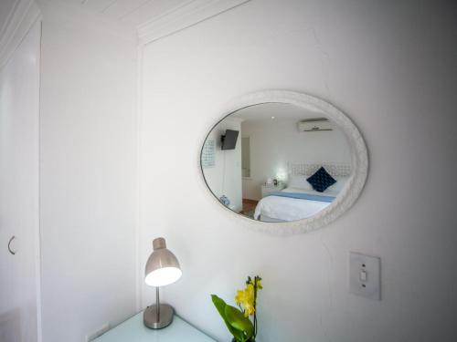 a white room with a mirror and a bed at Cosimi Guest House in Durbanville