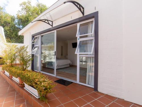 a house with sliding glass doors on a patio at Cosimi Guest House in Durbanville