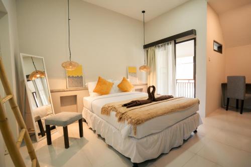 Un dormitorio con una cama y una silla y una ventana. en Kuta Sekeca CoWorking Apartment Close to Kuta Beach, en Jimbaran