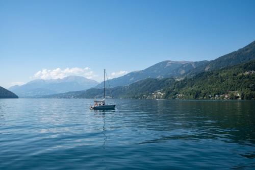 a sailboat on a lake with mountains in the background at Haus Kärnten in Döbriach
