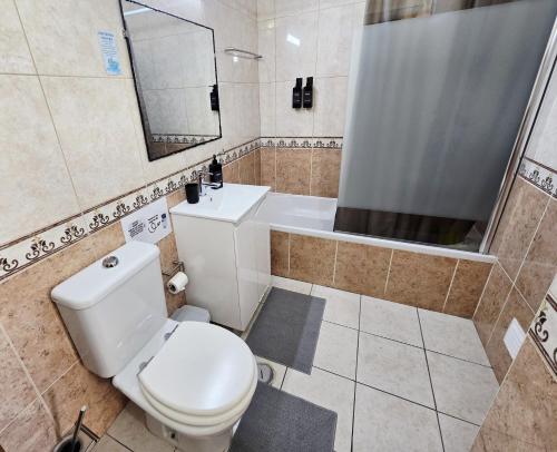 a bathroom with a toilet and a sink and a mirror at Dream Lagos B&B in Lagos