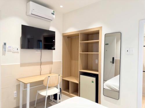 Habitación pequeña con escritorio y cama en Wander Lane Hotel & Coliving, en Ho Chi Minh