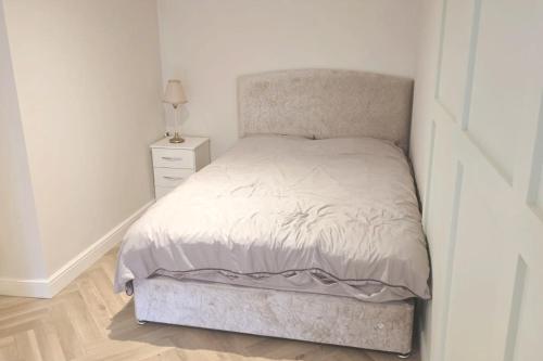 イーストボーンにあるCharming 1-Bed Retreat with Patio: Cozy & Centralのベッドルーム1室(ベッド1台、ナイトスタンド付)