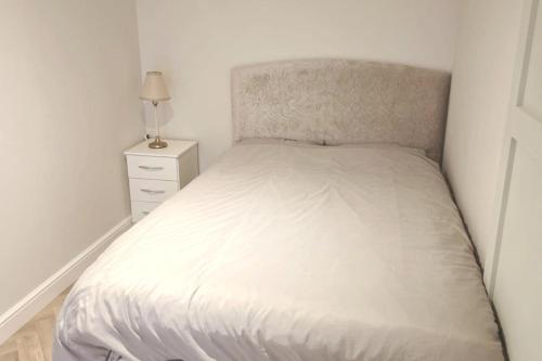 イーストボーンにあるCharming 1-Bed Retreat with Patio: Cozy & Centralの小さなベッドルーム(白いベッド1台、ナイトスタンド付)