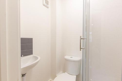 a white bathroom with a toilet and a sink at Radstock Road - Room 3a in Southampton
